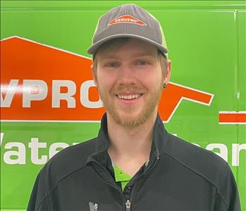 Male Technician, Avery, standing in front of green SERVPRO vehicle