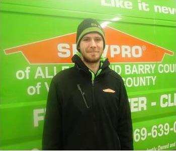 Male employee, Nick, standing in front of SERVPRO green vehicle
